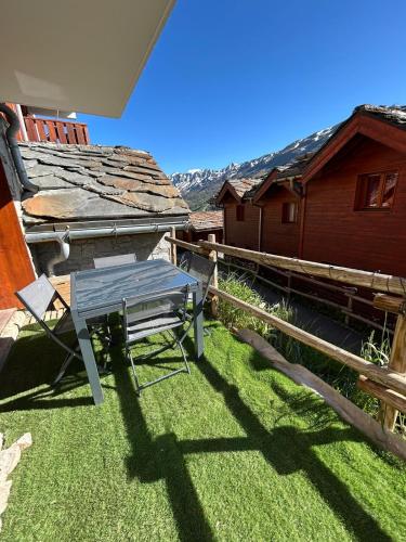 a bench sitting on the grass next to a house at Le Chardon Vert in Valmeinier