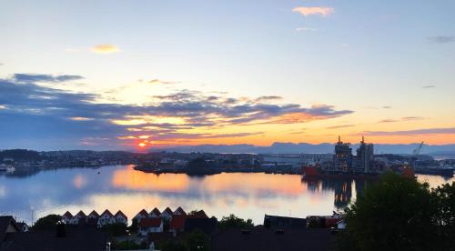 a sunset over a large river with a city at Panorama Byfjorden in Stavanger