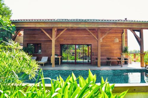 une villa avec une piscine et une maison dans l'établissement Villa éco-lodge sur pilotis - Piscine, Vélo, Plancha - entre Bayonne et Hossegor, à Saint-Laurent-de-Gosse