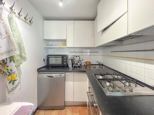 a kitchen with white cabinets and a stove top oven at Attic Castel Sant'Angelo - Pantheon in Rome