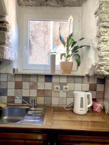 a kitchen counter with a sink and a window at Guesthouse Vicelic in Dubrovnik