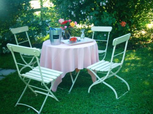 a table with a pink tablecloth and four chairs at Hof ter Wallen in Zoutleeuw