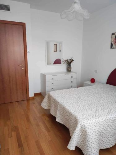 a white bedroom with a bed and a wooden floor at MARIA HOUSE for Agripolis in Legnaro