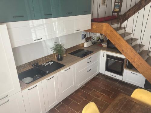 une cuisine avec des placards blancs et un escalier dans l'établissement Maison centre-ville Fleurance, à Fleurance