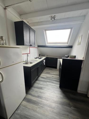 une cuisine avec des appareils électroménagers blancs et une fenêtre dans l'établissement WingFlat Appartement Entier Centre Ville Proche Naval Cité de la mer Quartier Calme, à Cherbourg en Cotentin