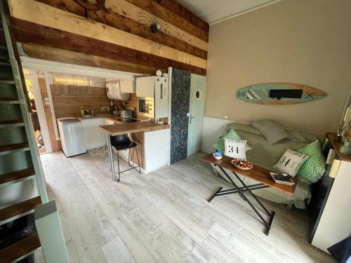 Cette petite chambre comprend un canapé et une table. dans l'établissement Appartement avec terrasse à 50 m de la plage, à Valras-Plage