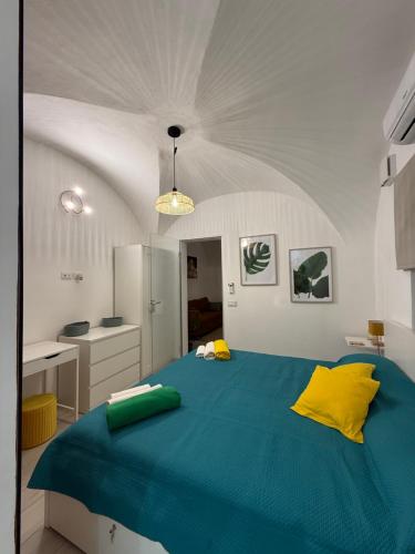 a bedroom with a large blue bed with yellow pillows at Aradas Home in Catania
