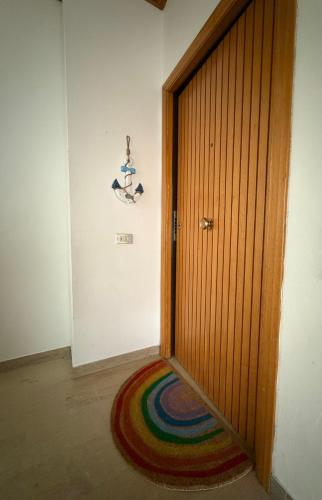 a room with a wooden door and a colorful rug at Grande appartamento Stella Marina in Misano Adriatico