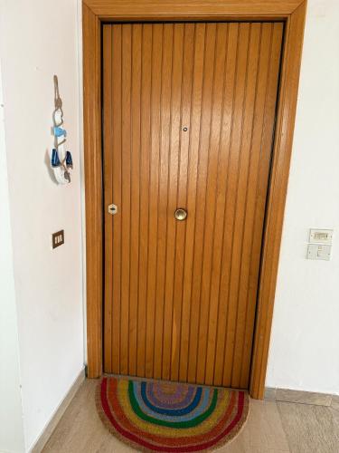 a wooden door in a room with a colorful rug at Grande appartamento Stella Marina in Misano Adriatico