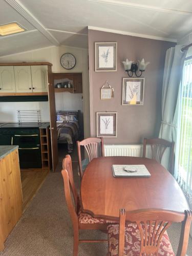 a kitchen and dining room with a wooden table and chairs at A7 caravan The Chase Ingoldmells in Ingoldmells