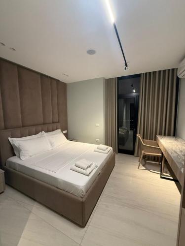 a bedroom with a large bed and a bathroom at ReiVal Hotel Marina Vlore in Vlorë