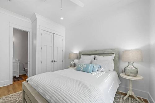 a white bedroom with a white bed with blue pillows at Gorgeous Gerev Home in Oberlech