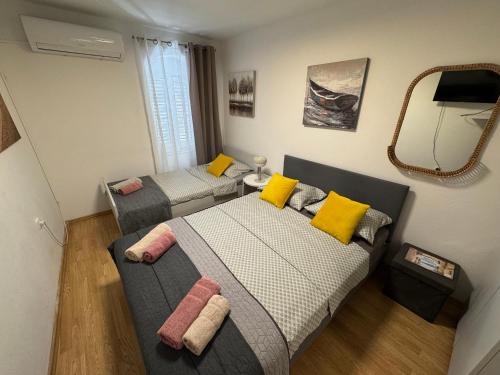 a small bedroom with two beds and a mirror at Blago Star Split Center in Split