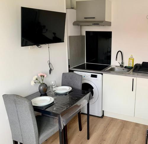 La cuisine est équipée d'une table, d'un évier et d'un lave-vaisselle. dans l'établissement Le Ptit Maisy, à Grandcamp-Maisy