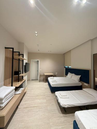 a hotel room with two beds and a television at ReiVal Hotel Marina Vlore in Vlorë