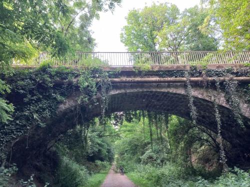 a bridge over a dirt road with a trail at gîte de LA LANFRAYERE in Saint-Mars-sur-Colmont