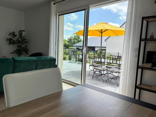 - un salon avec une table et un parasol dans l'établissement La Maison des Copains au coeur du DDAY, à Carentan