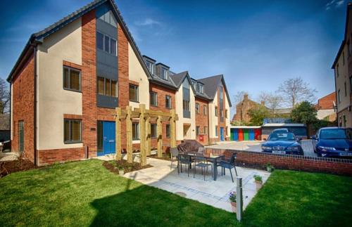 a house with a table and chairs in a yard at Pottergate Apartments 3 bedroom 2 bathroom Central Luxury Apartment in Norwich