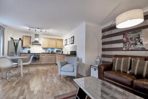 a living room and kitchen with a couch and a table at Pottergate Apartments 3 bedroom 2 bathroom Central Luxury Apartment in Norwich