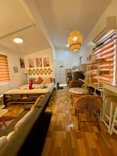 a room with two beds and a couch and chairs at Olango Island - S&E-1 Tiny Guest House Fully Furnished with Washer, Wi-Fi, Netflix & King-size Bed in Lapu Lapu City