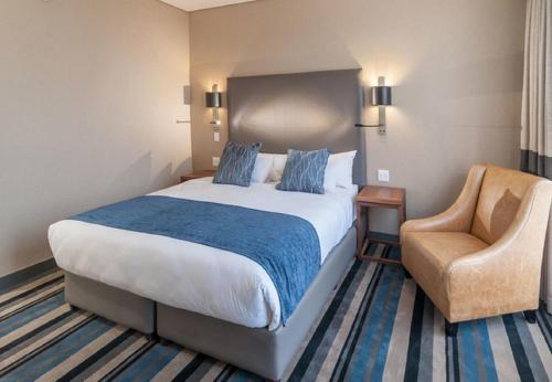 a hotel room with a bed and a chair at Hotel Goodwill Stay Near Delhi Airport in New Delhi