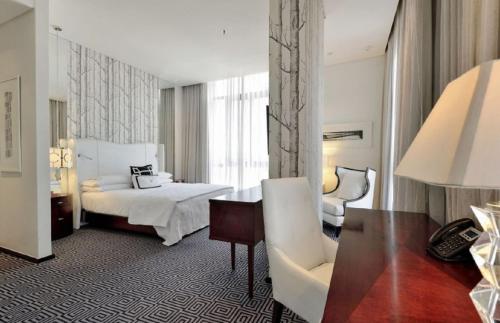 a hotel room with a bed and a desk at Hotel Goodwill Stay Near Delhi Airport in New Delhi