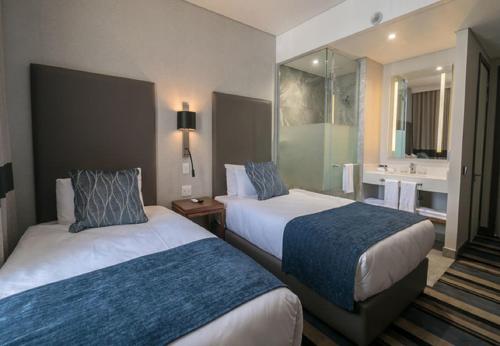 a hotel room with two beds and a bathroom at Hotel Goodwill Stay Near Delhi Airport in New Delhi
