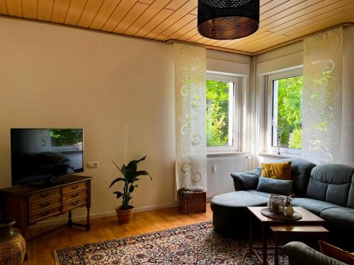 a living room with a couch and a tv at Ferienwohnung am Kurwald, Nähe Kliniken, 88qm, Parkplatz in Bad Lippspringe