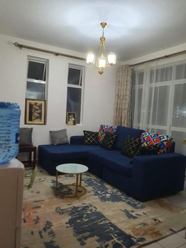 a living room with a blue couch and a table at Regional Homes Ke Racecourse Gardens in Nairobi