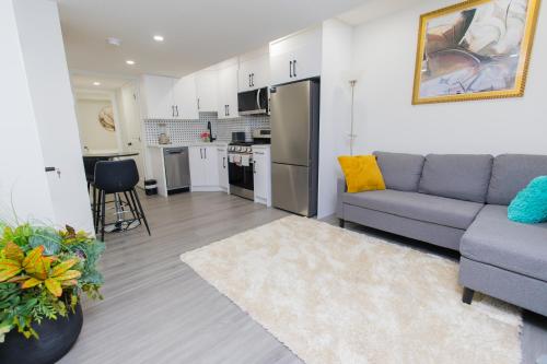 un salon avec un canapé et une cuisine dans l'établissement Cozy Quarters Your Comfy Haven, à Calgary