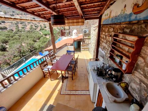 a house with a balcony with a sink and a table at Elounda Traditional Homes of Crete in Elounda