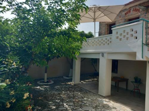 a house with a balcony with an umbrella at traditional village house in Ariokhórion