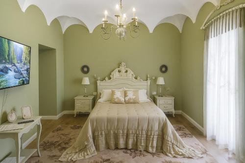 una camera da letto con un letto grande e un lampadario di Hotel Boutique iulia 5 Estrellas a Zafra