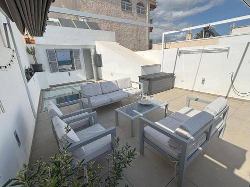 a patio with a couch and chairs and a table at Casa Cala del Mar in Cala del Moral