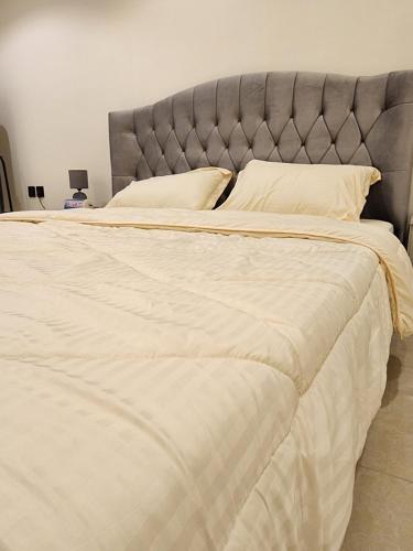 a large bed with white sheets and pillows at استوديو للايجار in Quai