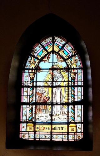 a stained glass window in a church with an angel at Terre - Le - Sart in Neufchâteau