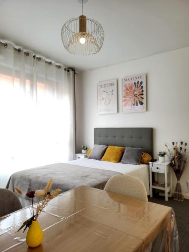 une chambre avec un grand lit et une table dans l'établissement Paris à 7 minutes en métro, à Rosny-sous-Bois