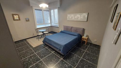 a bedroom with a blue bed and a table at 5 Terre SEA VIEW in Riomaggiore