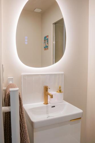 une salle de bain avec un lavabo et un miroir dans l'établissement Le Nid Terracotta Charme et Sérénité à Saint-Brieuc, à Saint-Brieuc