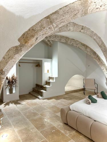 - une chambre avec un lit et un sol en pierre dans l'établissement Les Voûtes de Blois, à Blois