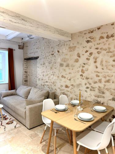 un salon avec une table en bois et des chaises blanches dans l'établissement Les Voûtes de Blois, à Blois