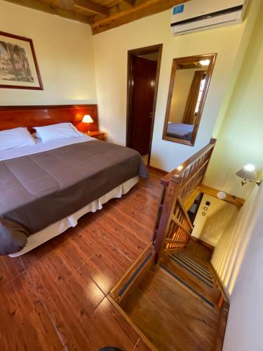 a bedroom with a bed and a staircase with a mirror at Hosteria Sirenuse in Mar del Plata