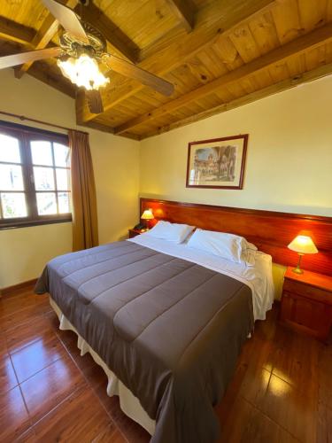 a bedroom with a large bed and a wooden ceiling at Hosteria Sirenuse in Mar del Plata