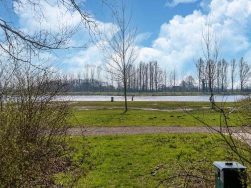 a field with trees and a body of water at Sun-Soaked Bungalow in Simonshaven in Simonshaven