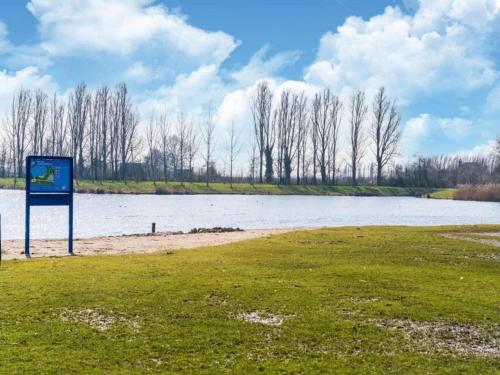 a sign in a field next to a body of water at Sun-Soaked Bungalow in Simonshaven in Simonshaven