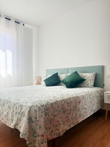 a bedroom with a bed with green pillows at Apartamento Altamar Portonovo, 100 m playa in Sanxenxo