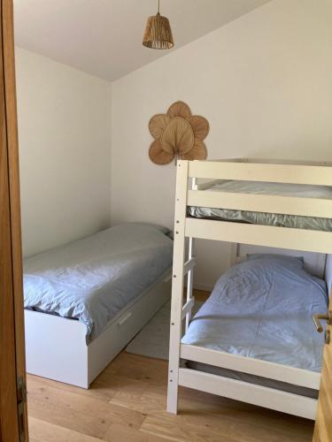 une chambre avec deux lits superposés et une lampe dans l'établissement Maison Tamaris proche de l'Océan, à LʼAiguillon-sur-Vie