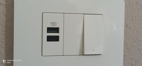 una macchina bianca con pulsanti su una parete bianca di Le Dimore del Sole int 8 a Olbia