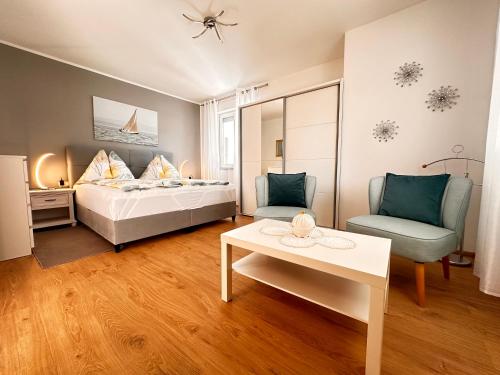 ファジャナにあるPark Plaza Apartmentsのベッドと椅子とテーブルのある寝室