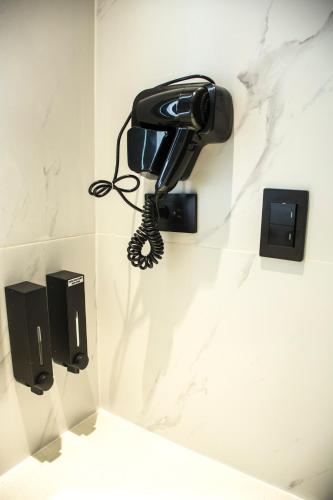 a phone hanging on a wall in a bathroom at Hotel Las Cascadas in San Pedro Sula
